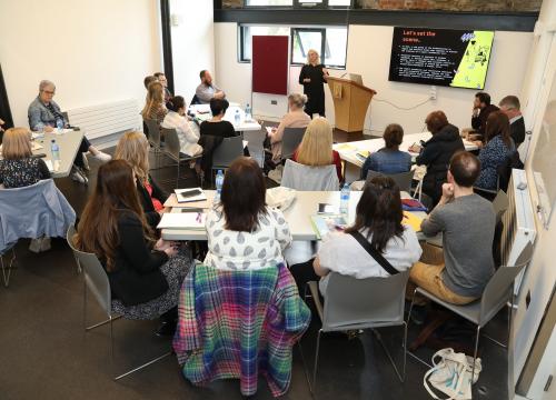 Photograph of Dr Lydia Devenney presenting on the Report Automation Tool at the Practitioners Forum 2022