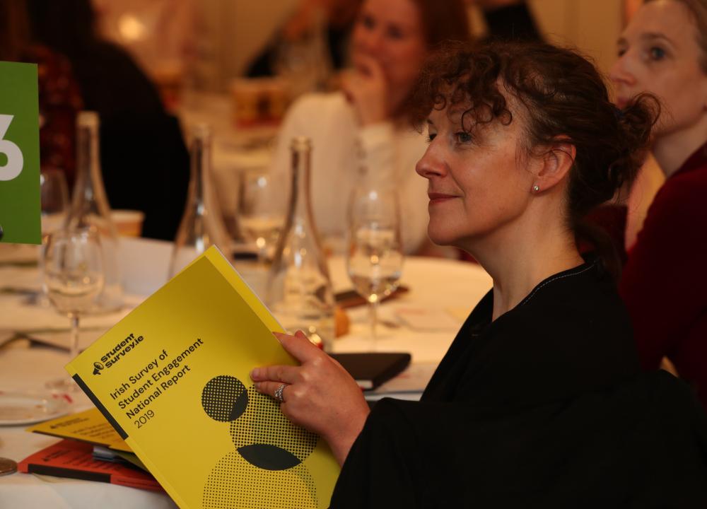 Photograph of woman reading StudentSurvey.ie National Report 2019 at the launch of the report